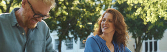 Smiling couple enjoying a relaxed moment outdoors, conveying confidence and connection during a date night while managing incontinence.