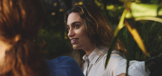 Woman listening attentively during a conversation in an outdoor setting, featured in an article about coping with the emotional side of menopause.