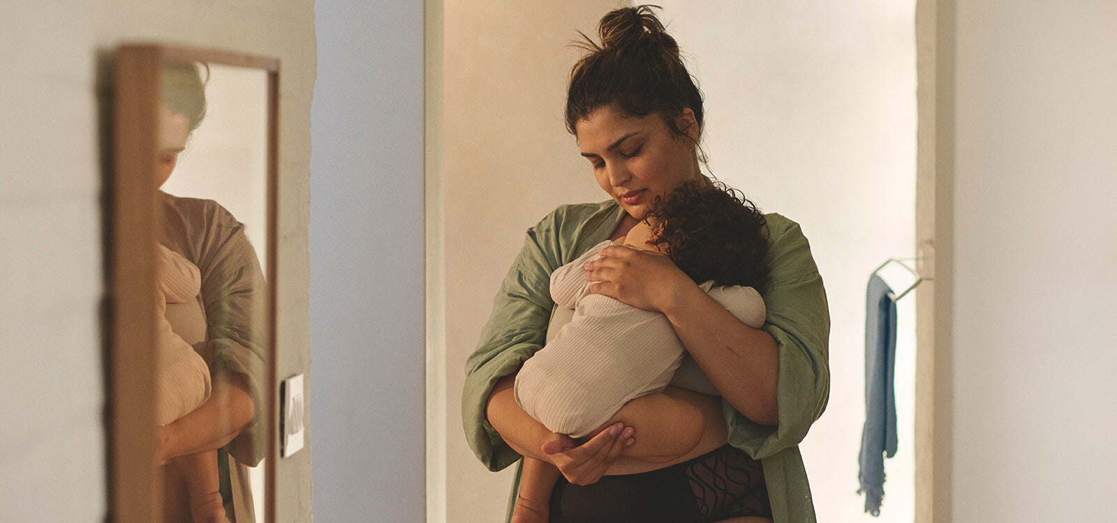 Mother gently holding her baby in a softly lit room, illustrating a moment of care in an article about frequent urination during pregnancy and related tips
