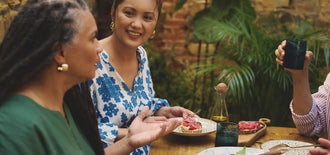 Group of adults enjoying a meal together outdoors, engaging in friendly conversation, featured in an article about foods and drinks that support bladder and kidney health.