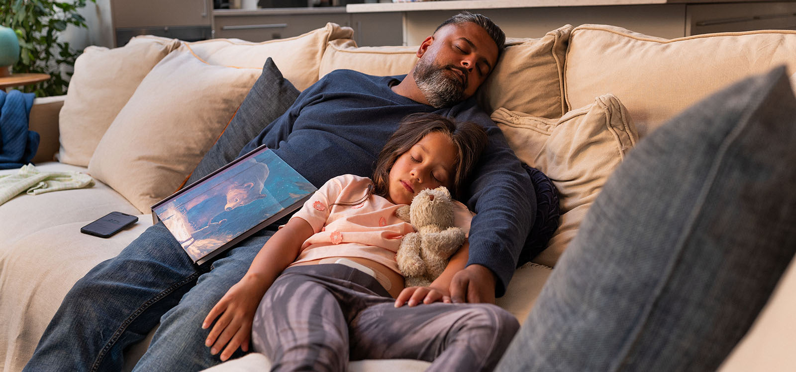 Father and daughter peacefully napping on the couch together, symbolising calm and balance through healthy lifestyle choices.