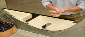 Person washing hands at a modern sink, representing hygiene and lifestyle habits linked to bladder health.