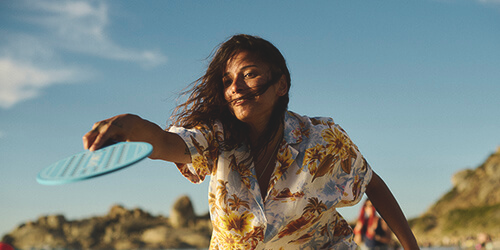 An image of a woman smiling playing a paddle sport