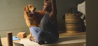 A woman doing yoga with a dog