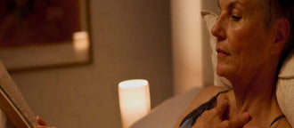 A woman reclines in bed reading