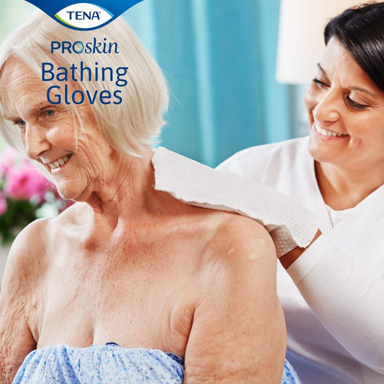 A woman uses the bathing glove on an older woman