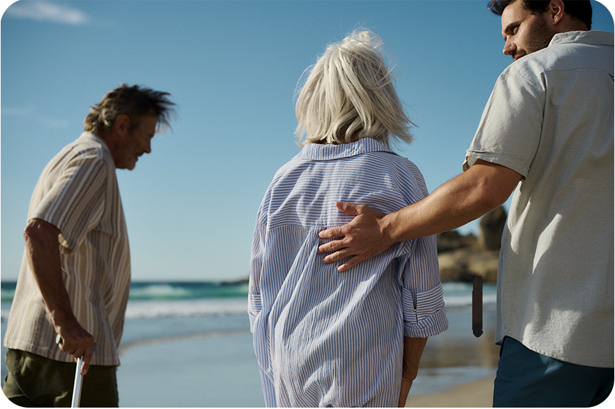 A picture of two men and a woman walking on a beach